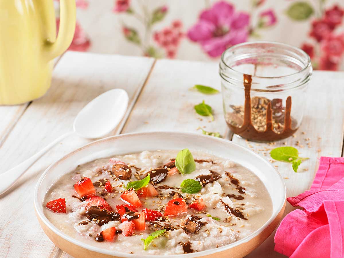 Porridge o crema de coco con chocolate, semillas y fresones