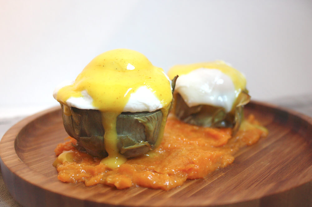 Huevos Benedict sobre alcachofa con puré de calabaza asada y salsa holandesa