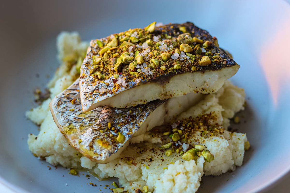 Corvina con puré de coliflor y pistachos picantes