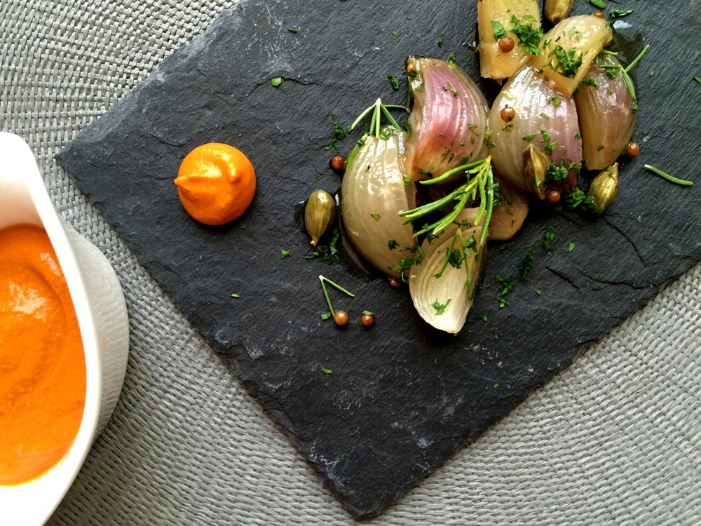 Cebollas dulces confitadas con salsa romesco